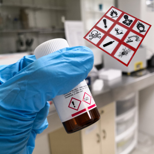 Hand with a safety glove holding a chemical reagent in an amber bottle. Background of a scientific research laboratory.